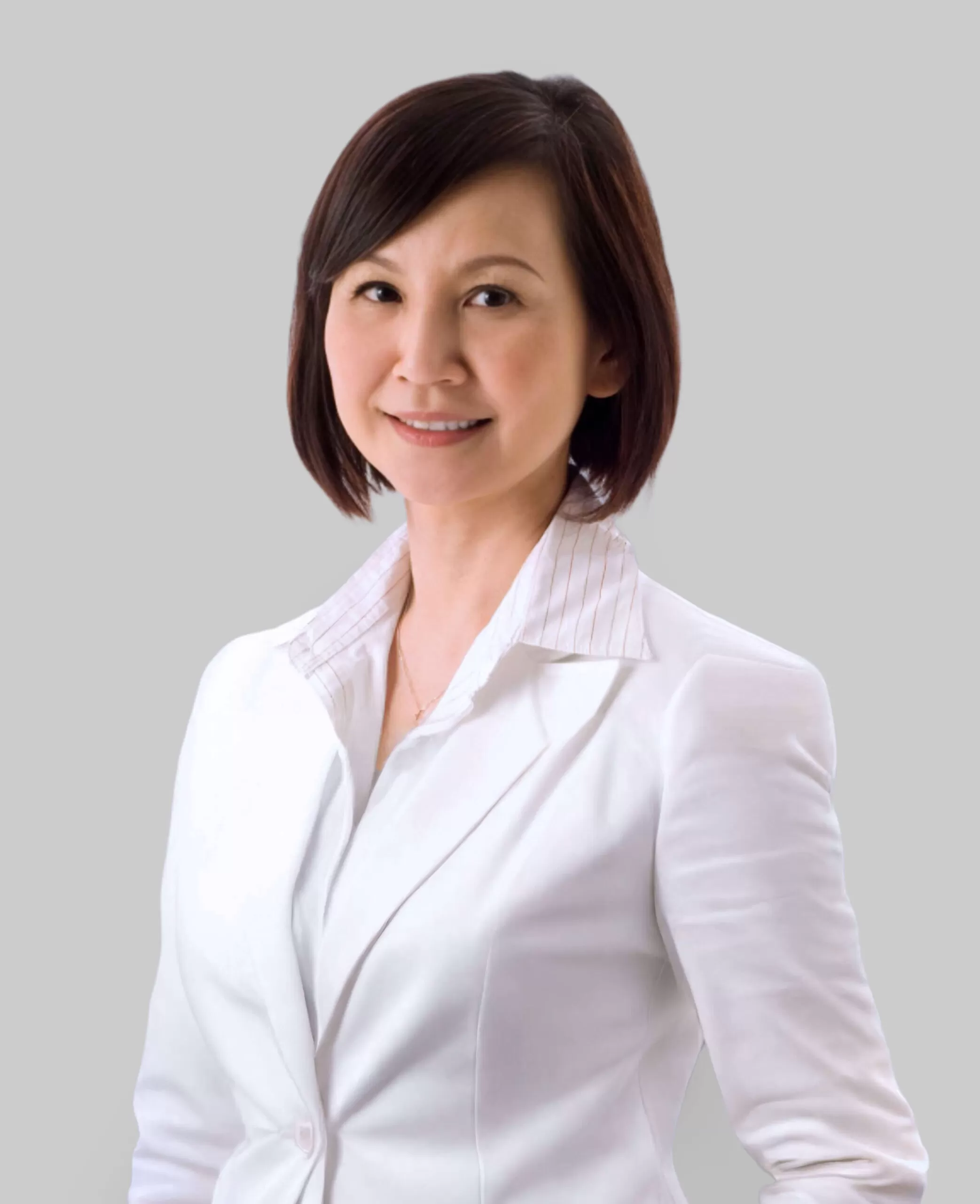 Professional woman wearing a white blazer, posing for a corporate headshot against a light gray background.